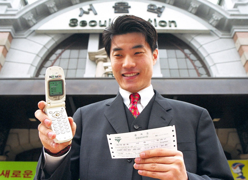 SK Telecom employee is shown confirming business expenses paid by e-Money NEMO before taking a business trip, by connecting to the NATE service via cellular phone.